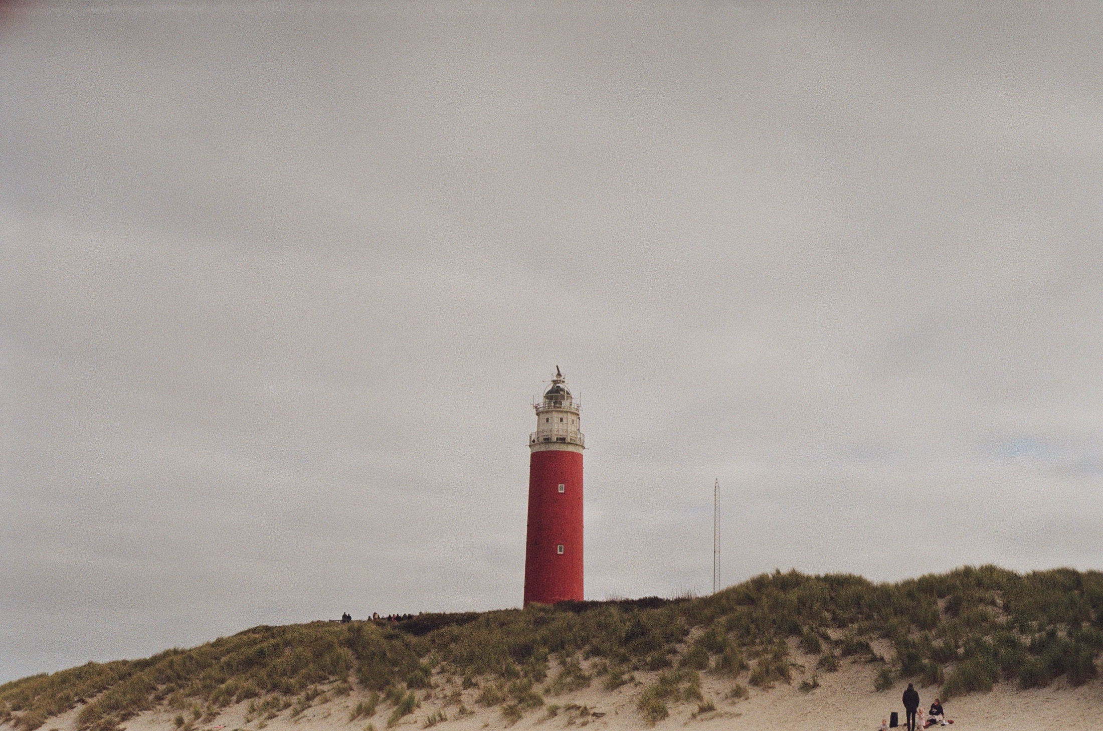 A red lighthouse beyond the dunes